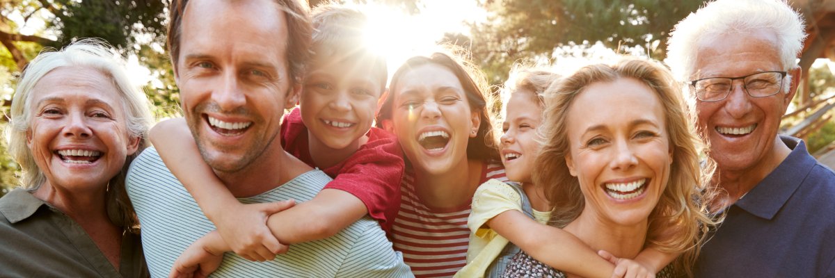 Outdoor Portrait Of Multi-Generation Family Walking In Countryside Against Flaring Sun