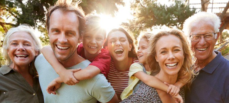 Outdoor Portrait Of Multi-Generation Family Walking In Countryside Against Flaring Sun